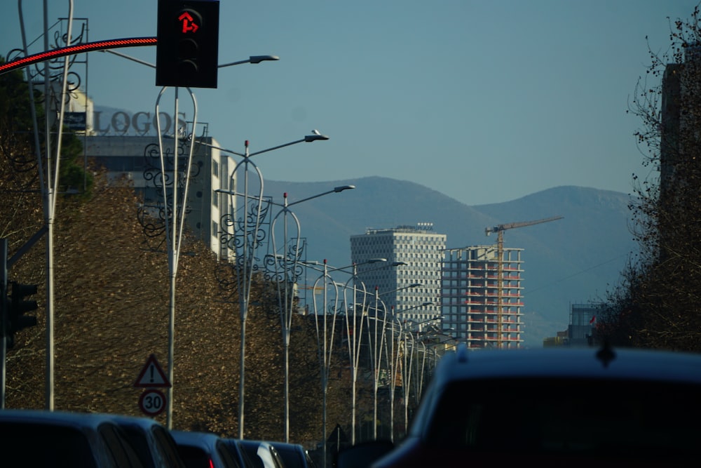 a city street filled with lots of traffic next to tall buildings