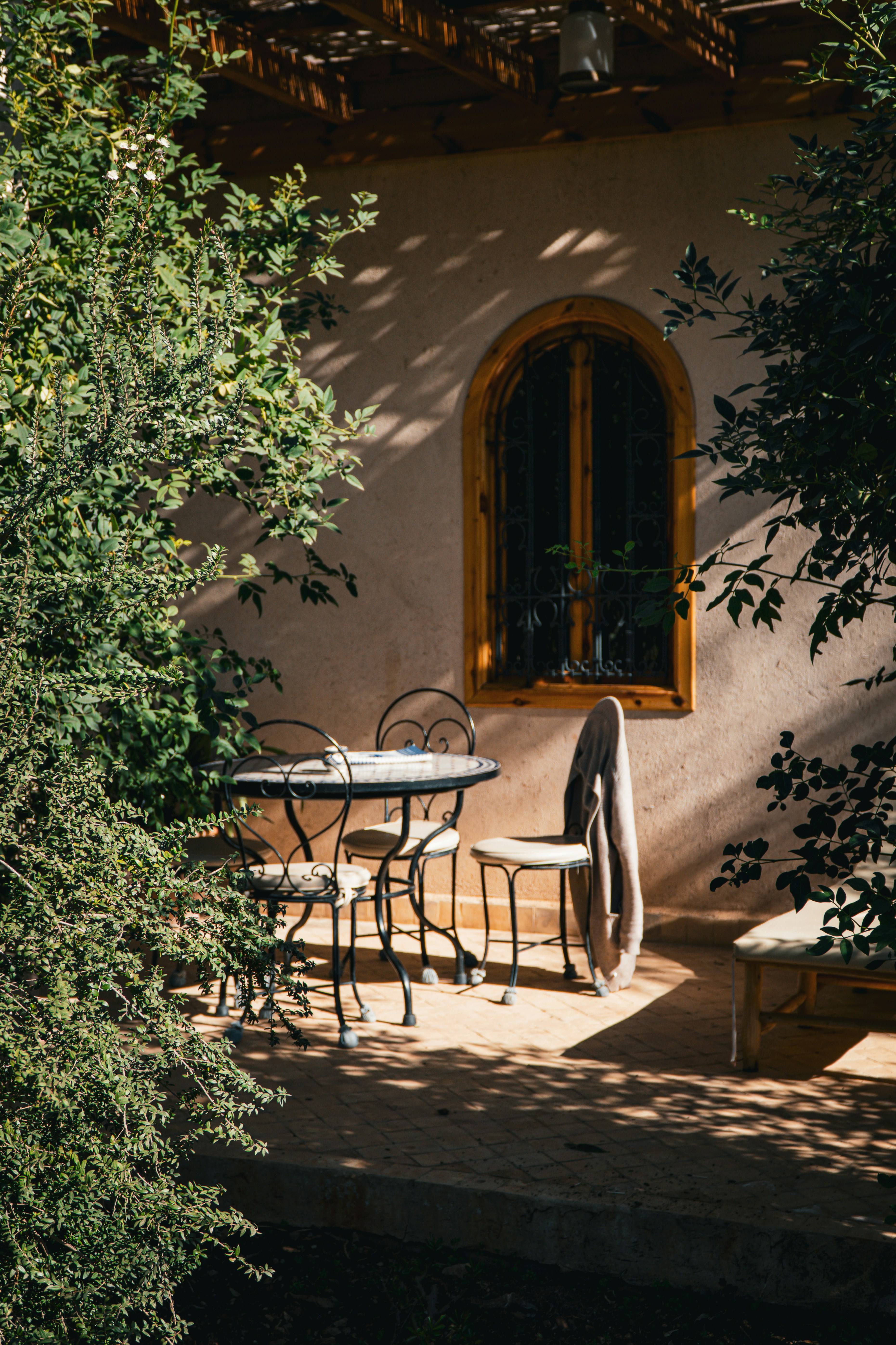 a patio with a table and chairs next to a tree