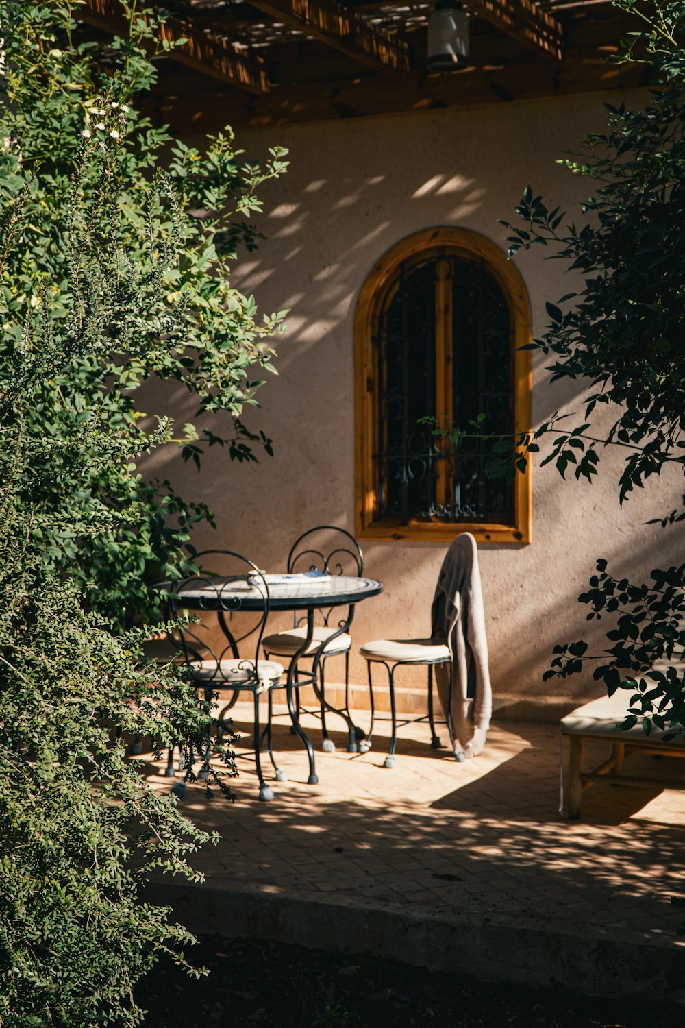 a patio with a table and chairs next to a tree