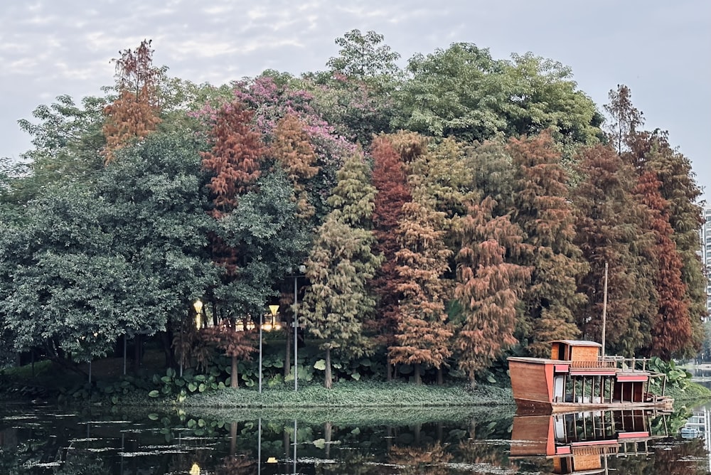 a boat floating on top of a lake surrounded by trees