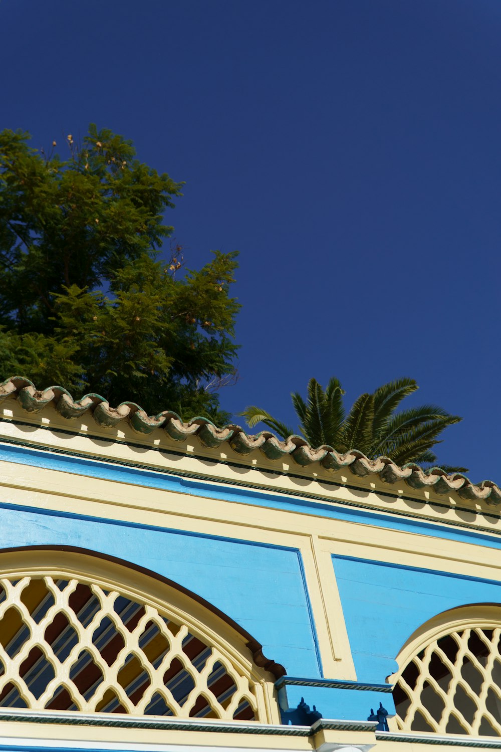 a blue and white building with a tree in the background