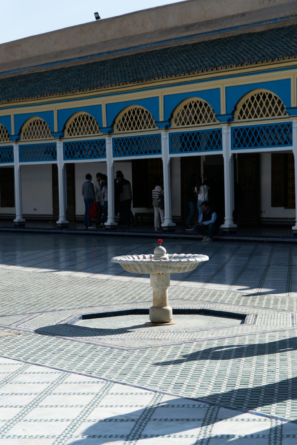 a white and blue building with a fountain in front of it