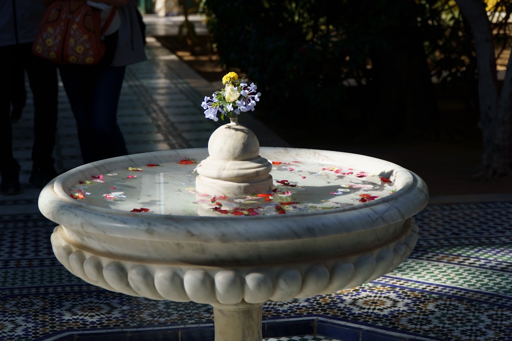 a fountain with a flower arrangement on top of it