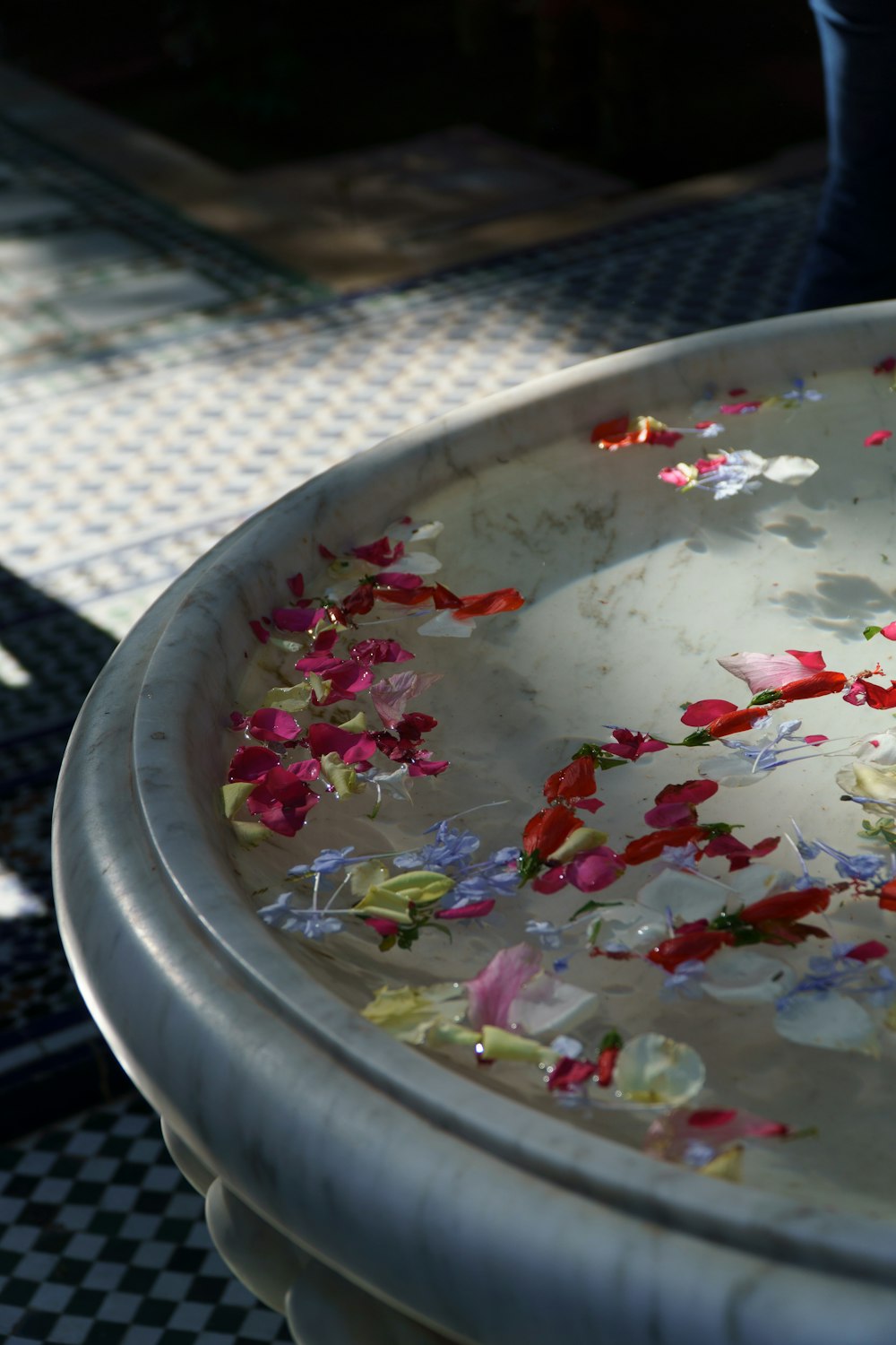 체크 무늬 바닥 위에 꽃으로 가득 찬 흰색 그릇
