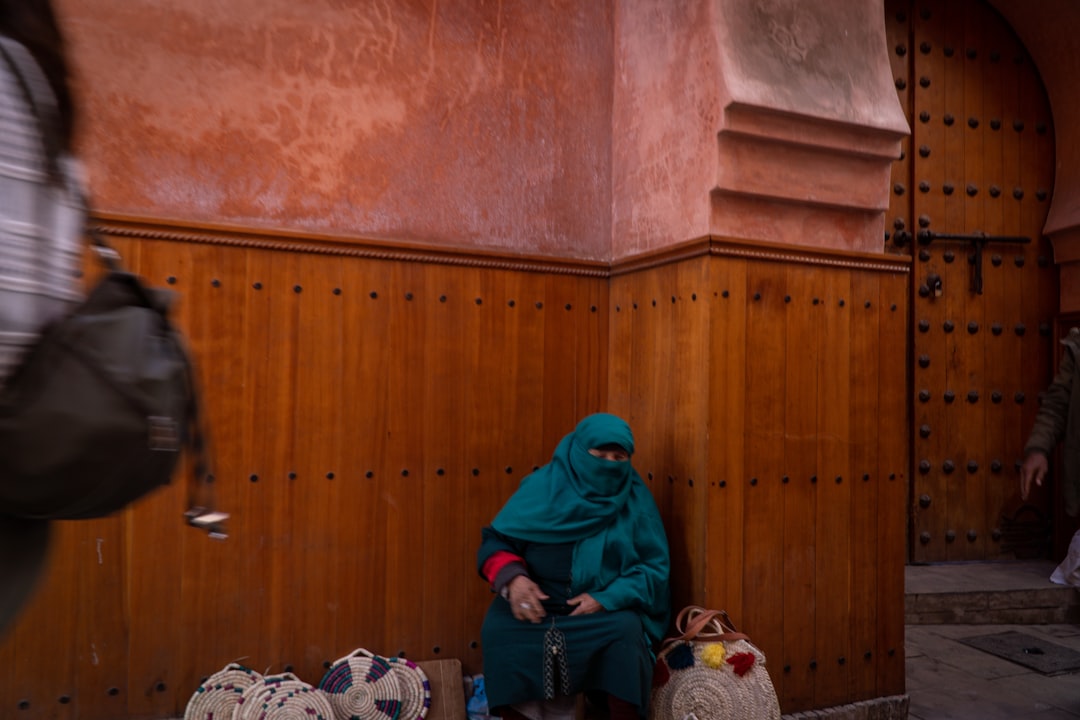 a woman sitting on the ground in front of a building,