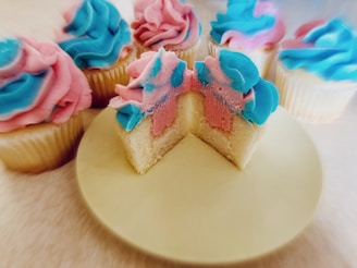 A colorful display of assorted pastel-colored cupcakes with cute kawaii faces.
