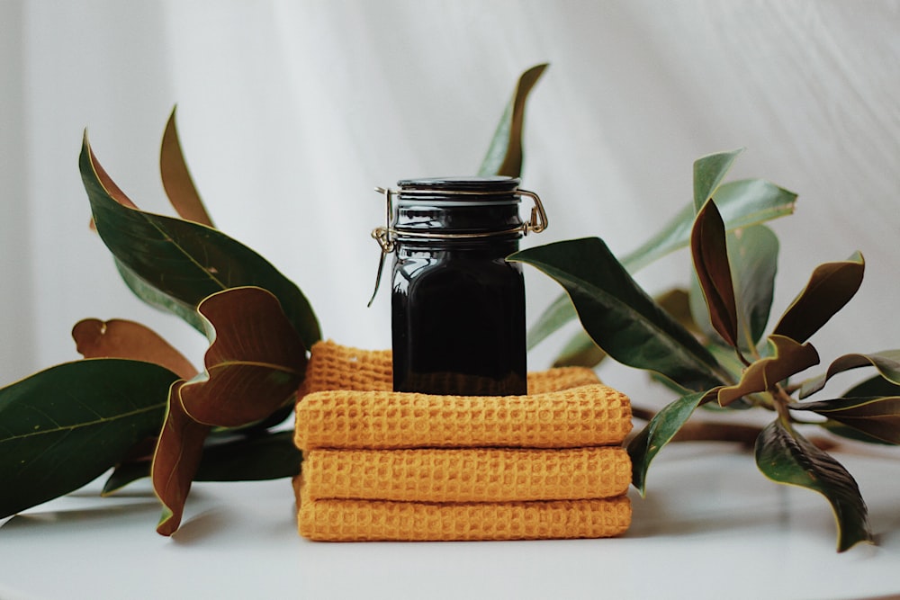 a bottle of liquid sitting on top of a stack of yellow towels