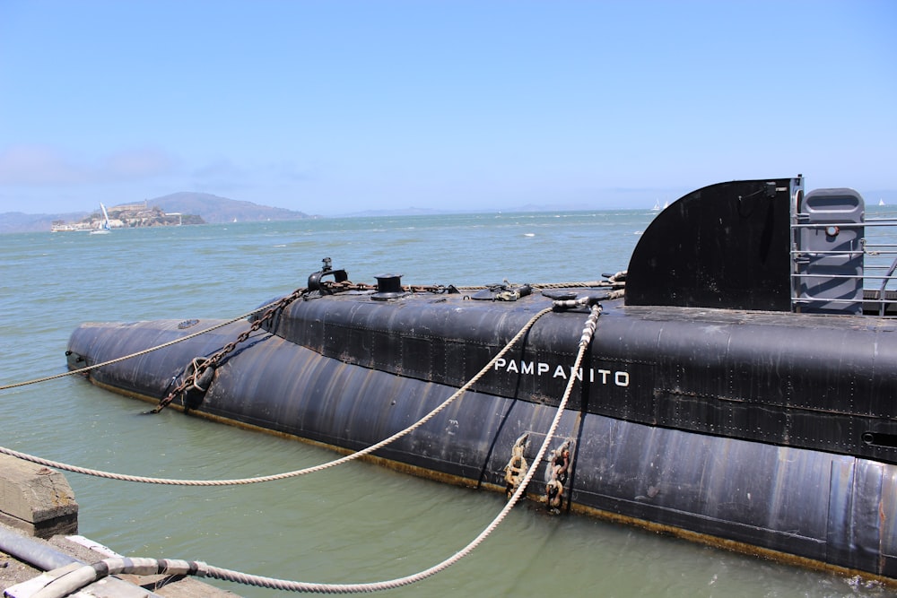 a large black submarine floating on top of a body of water