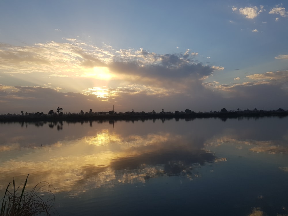 a large body of water with a sky in the background