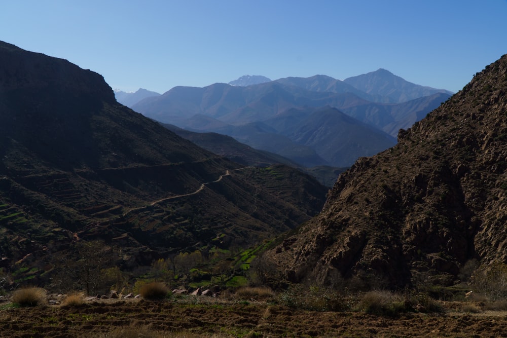 a mountain range with a winding road in the foreground