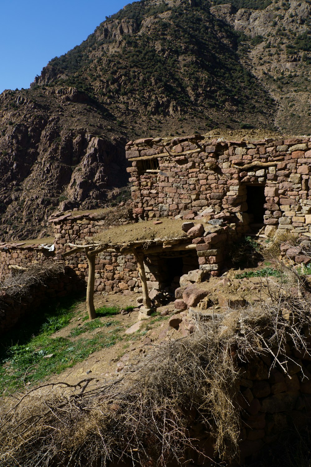 an old stone building with a mountain in the background