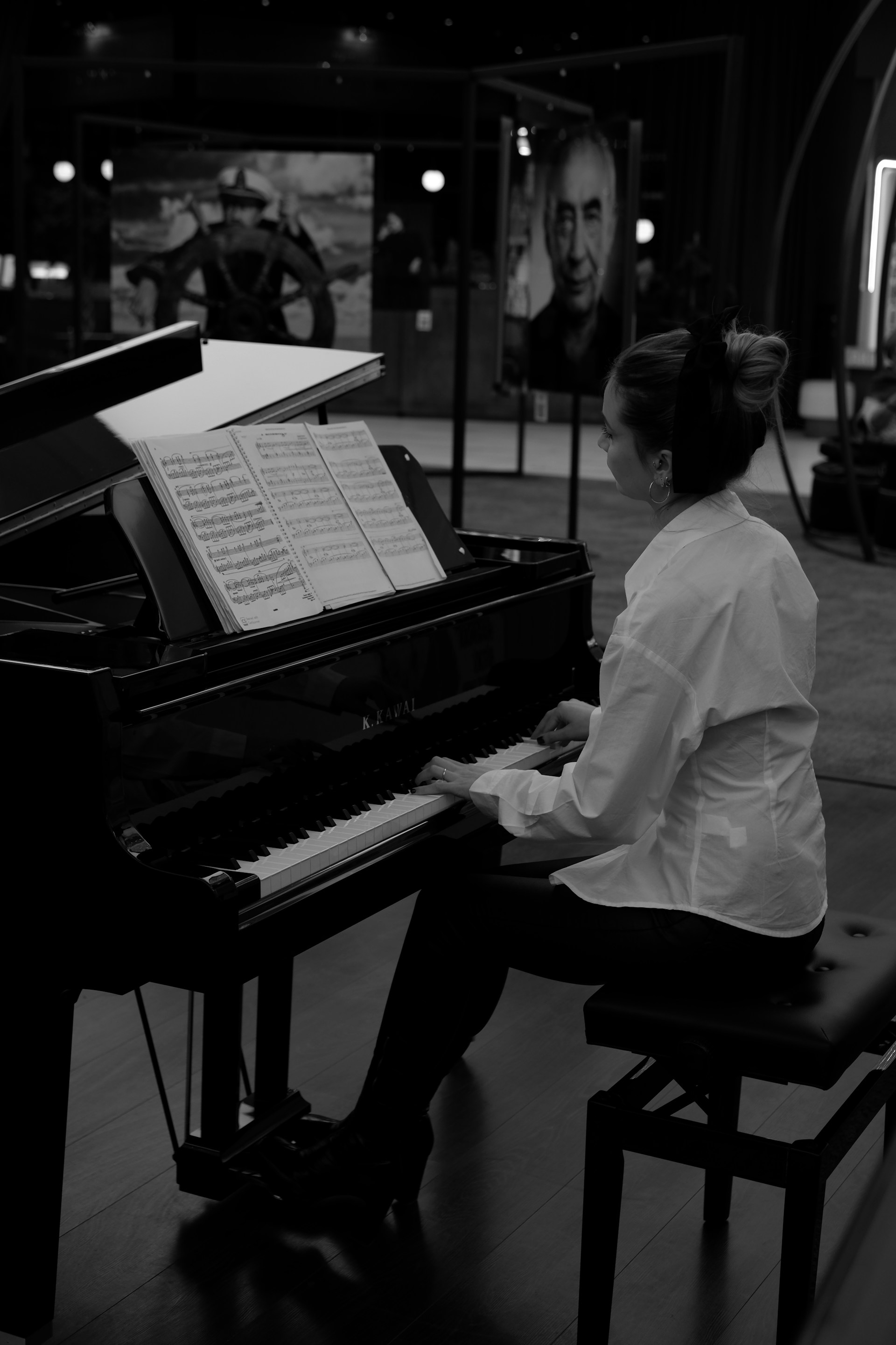 a woman sitting at a piano in a black and white photo