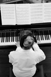 a young girl sitting at a piano playing music