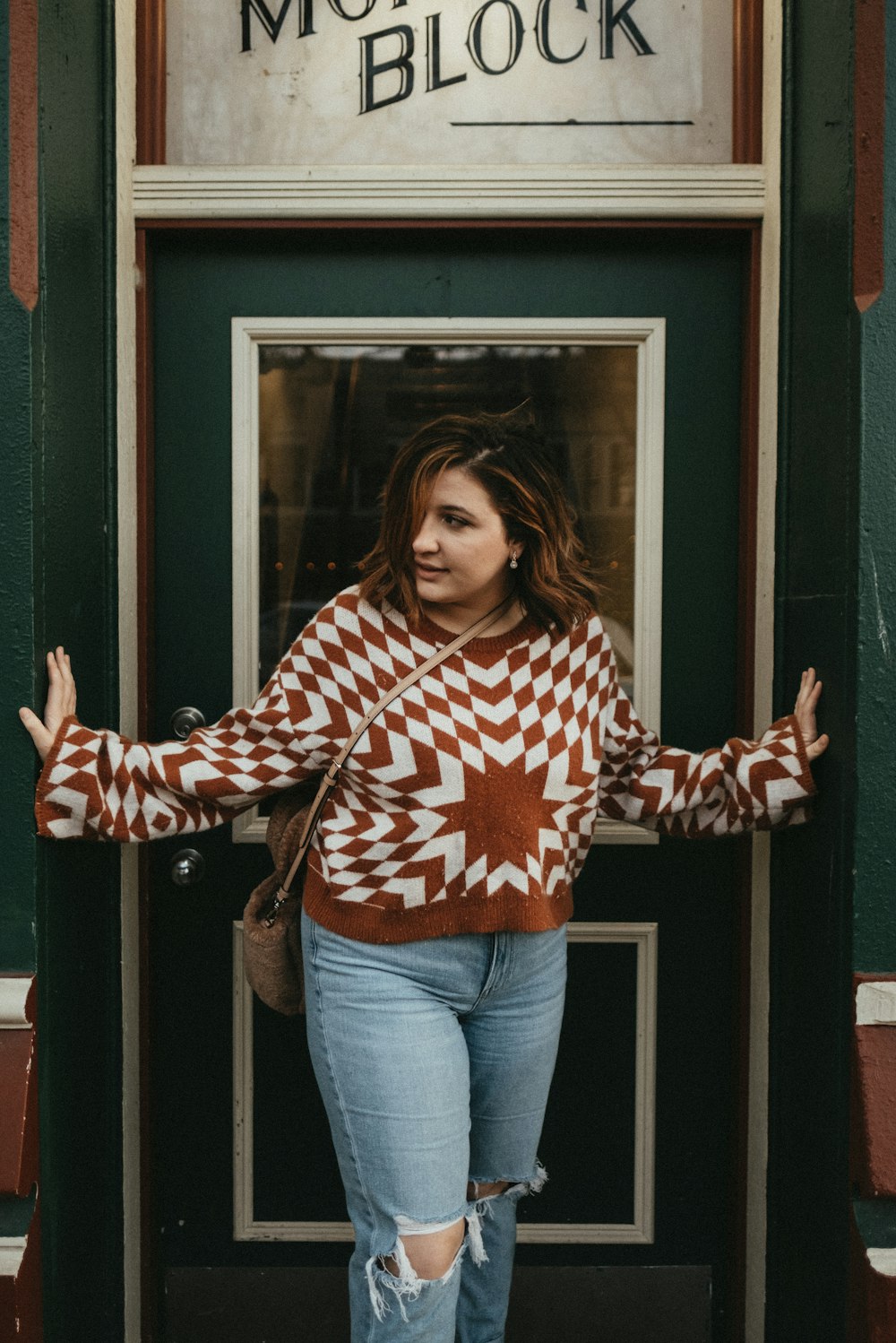 a woman standing in front of a green door