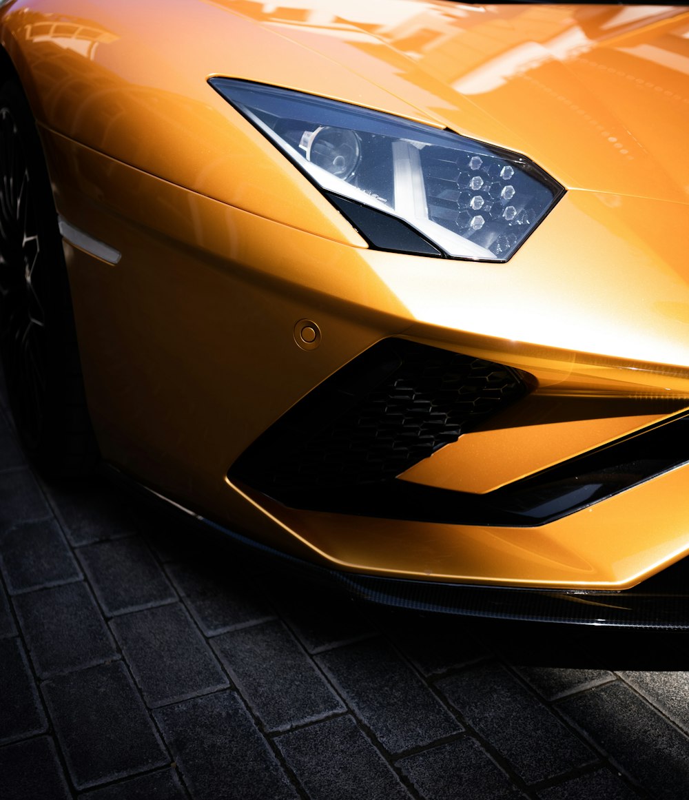 a close up of the front of a yellow sports car
