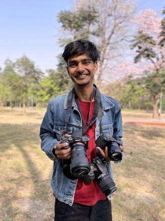 A group of diverse people happily exchanging cameras outdoors.