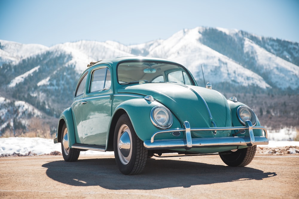 a green car parked in front of a mountain