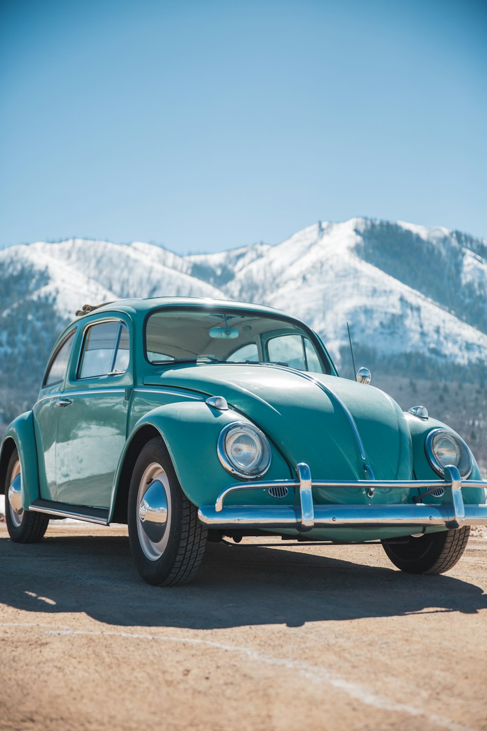 a green car parked in front of a mountain