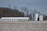 Photo of a large, durable steel agricultural bin standing strong on a snowy farm.