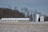 Photo of a large, durable steel agricultural bin standing strong on a snowy farm.