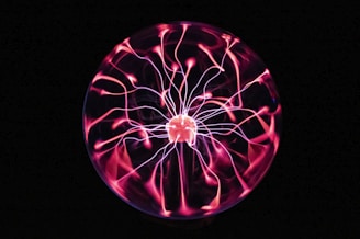 A glowing Van de Graaff generator coil with silvery streams of static electricity.