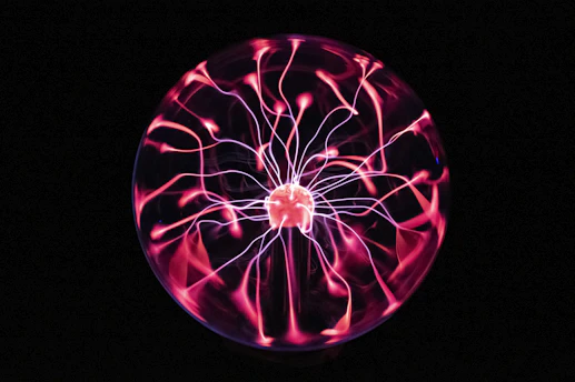 A glowing Tesla coil illuminating a dark room with electric arcs.