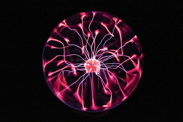 A glowing Van de Graaff generator coil with silvery streams of static electricity.