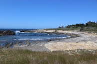A rocky coastline with waves gently crashing against the shore.