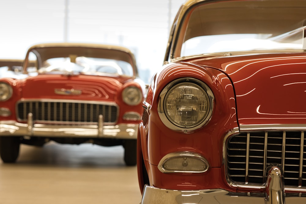 a couple of red cars parked next to each other