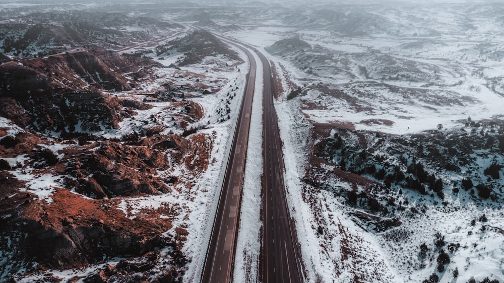 Una vista aérea de una carretera en las montañas cubiertas de nieve