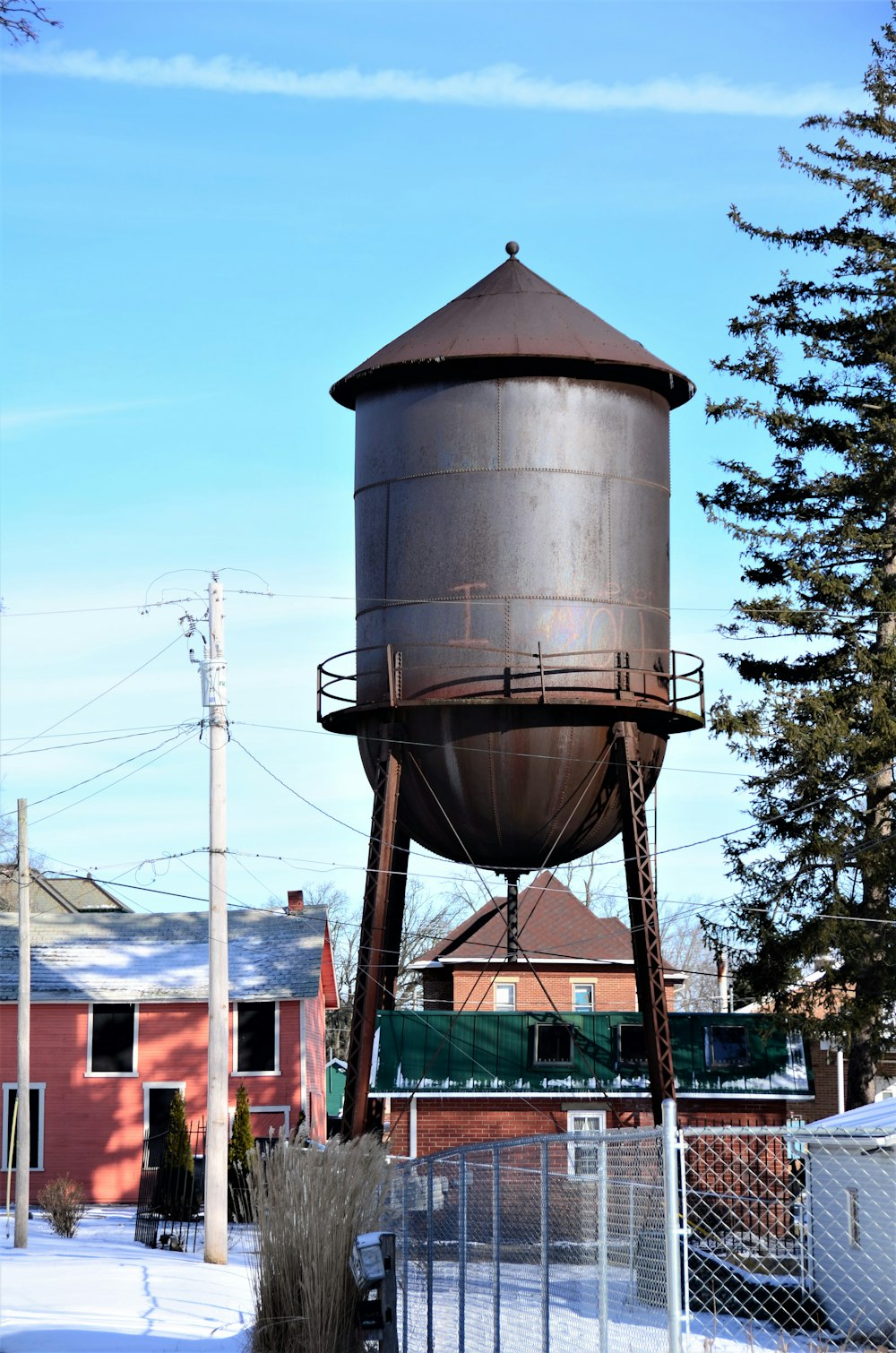 a large metal water tower sitting next to a fence