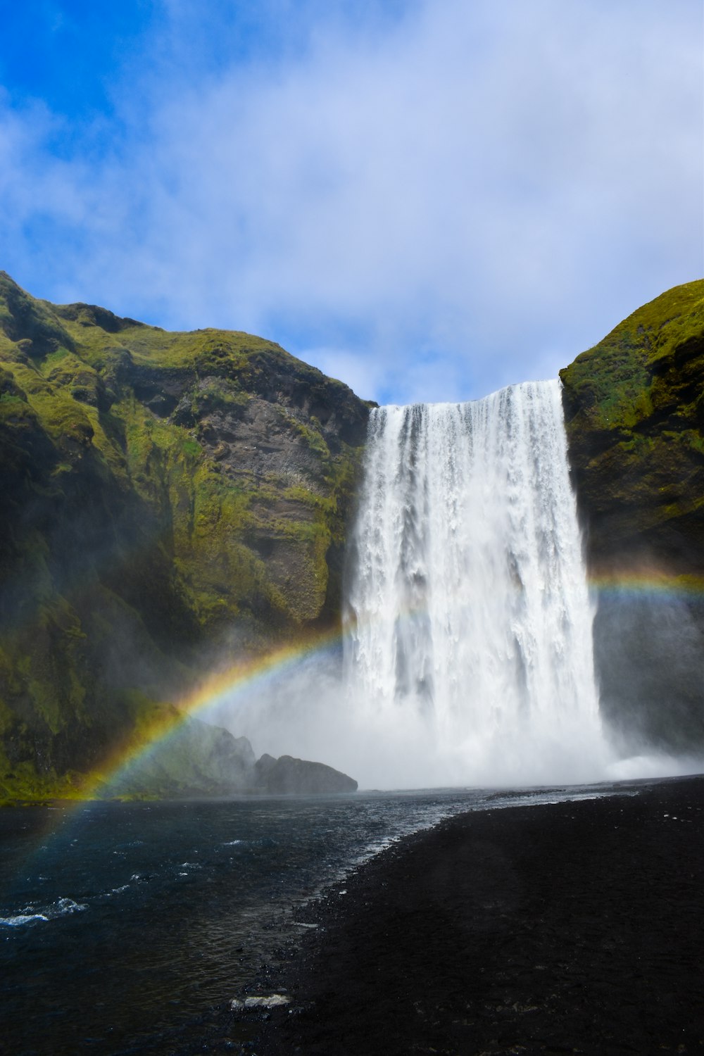 Ein Wasserfall mit einem Regenbogen in der Mitte