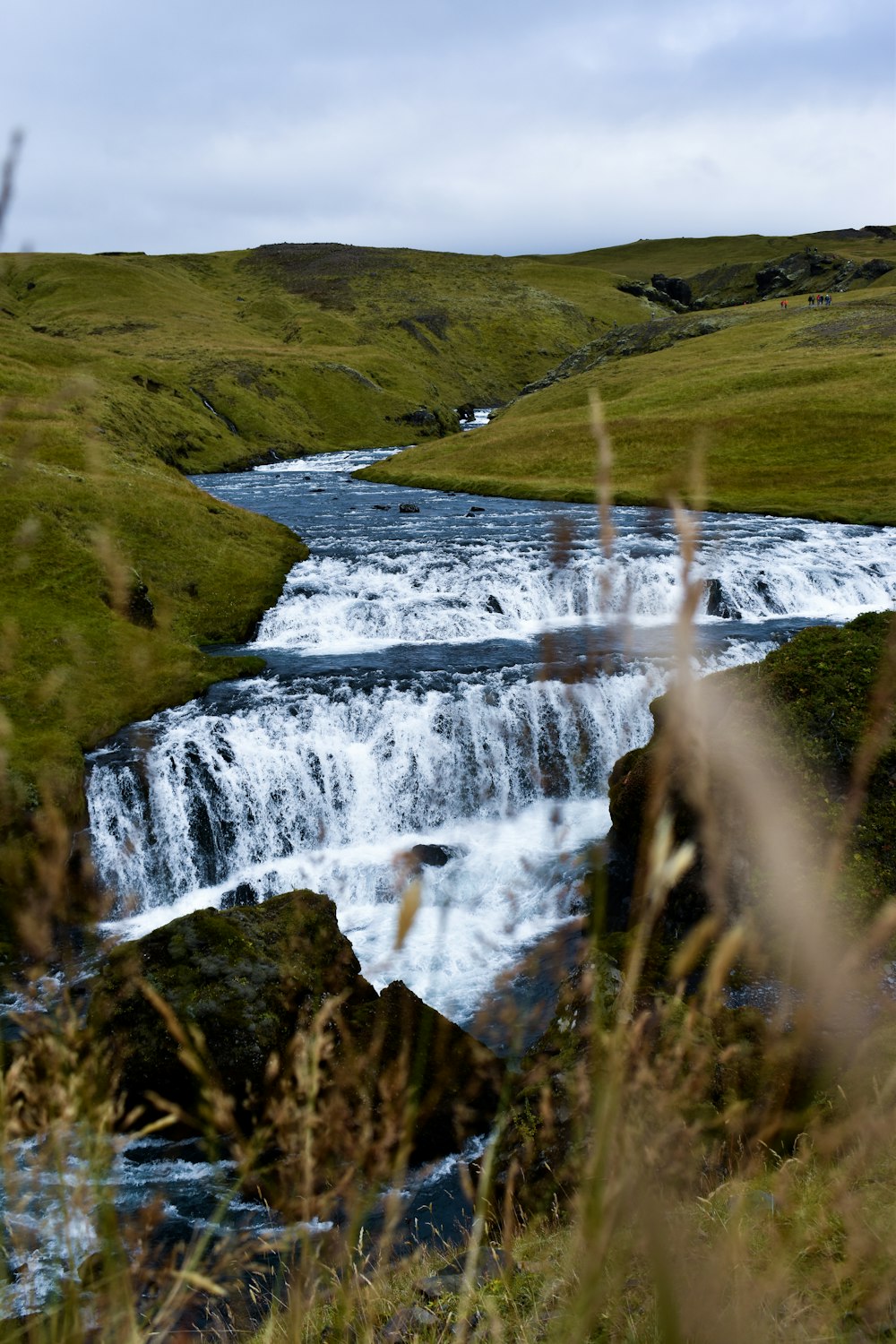 a river running through a lush green hillside