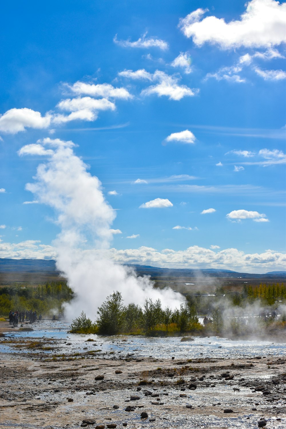 a geyser spewing out steam into the sky
