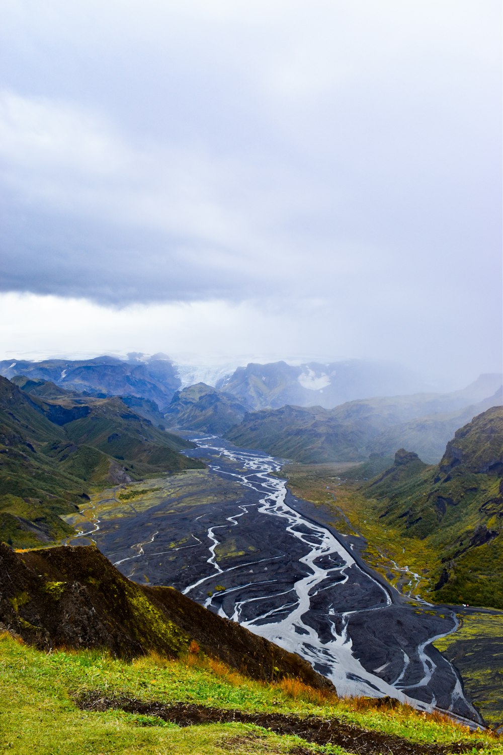 a river running through a valley surrounded by mountains