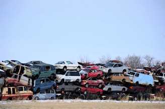 a large pile of old cars sitting in a field