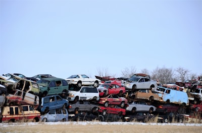 a large pile of old cars sitting in a field