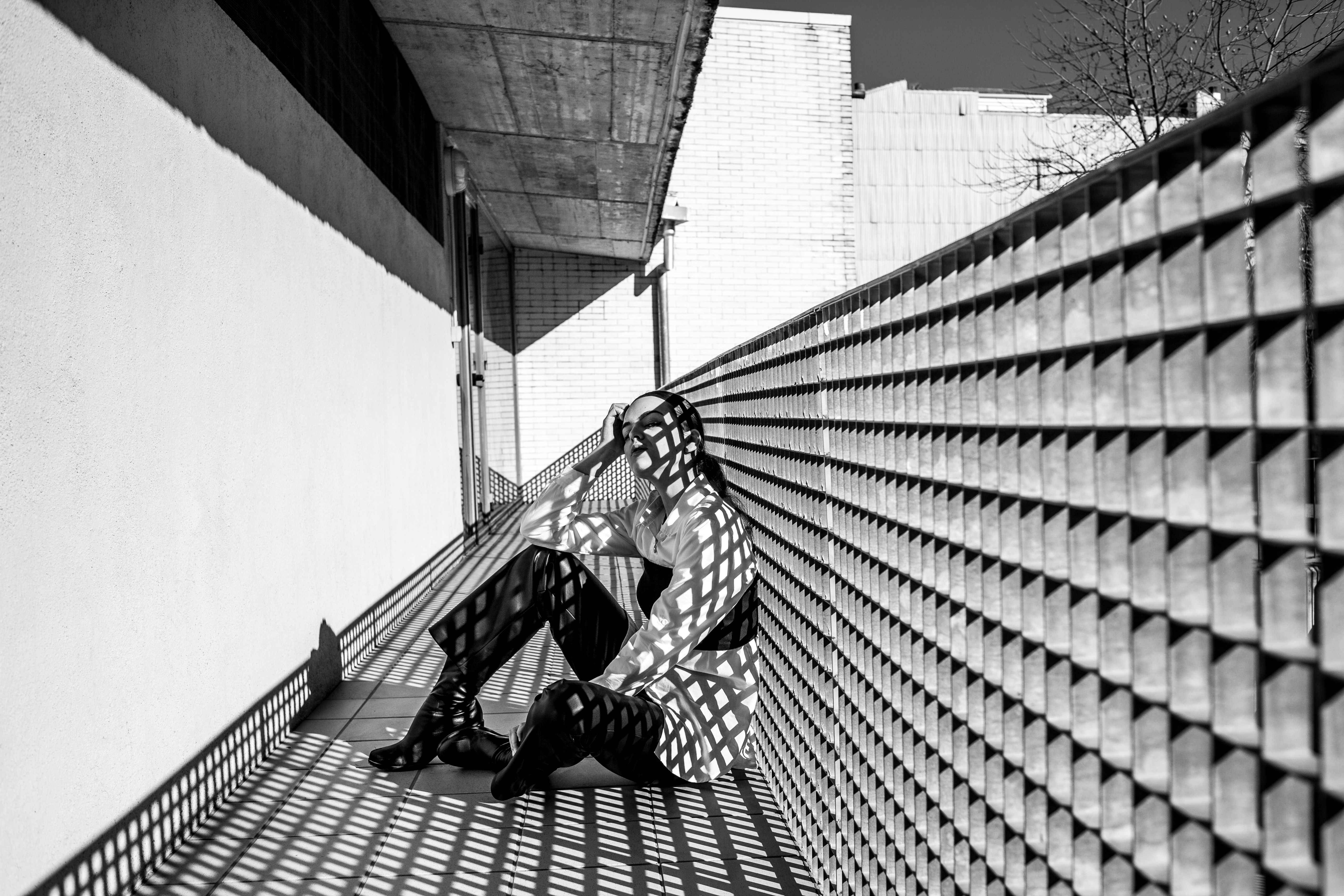 a black and white photo of a person sitting on a bench