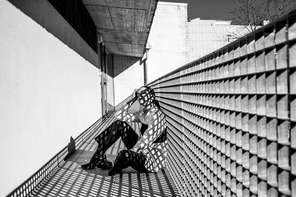 a black and white photo of a person sitting on a bench