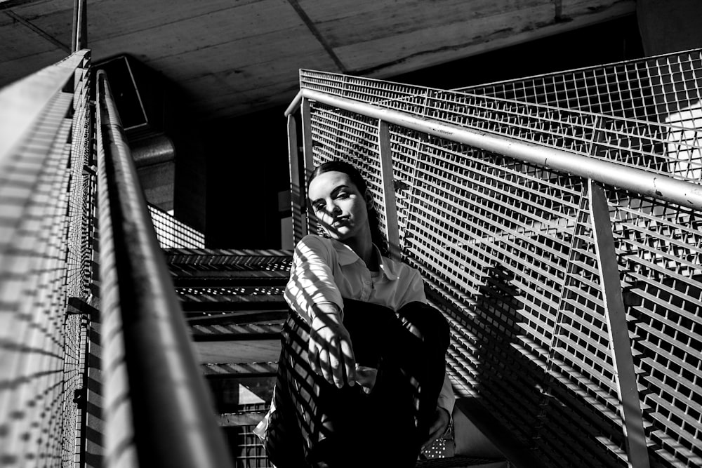 a man standing on a stair case next to a fence