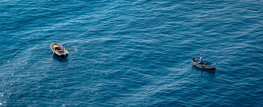 a couple of small boats floating on top of a large body of water