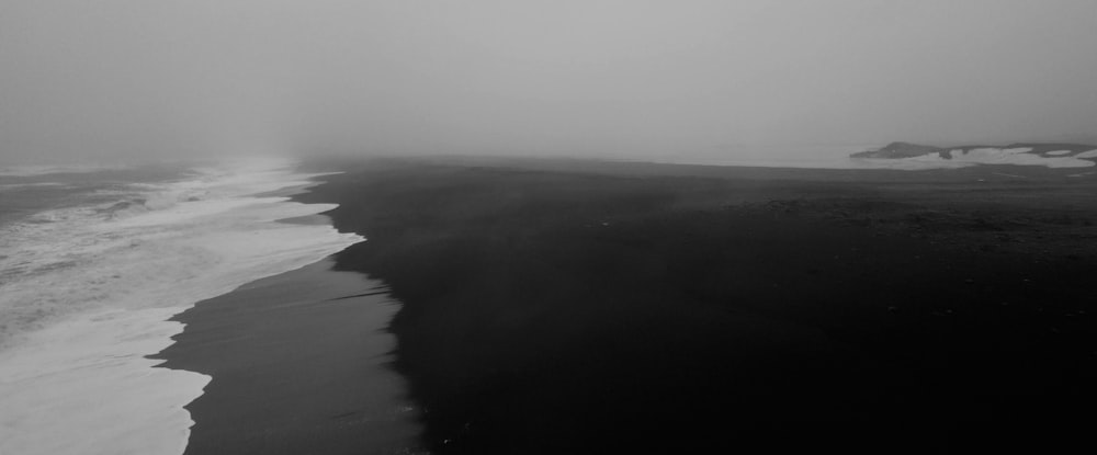 a black and white photo of a beach and ocean