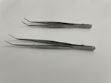 A set of stainless steel tweezers neatly arranged on a factory production line.
