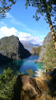Travelers enjoying a boat ride on a crystal-clear lake surrounded by towering cliffs.