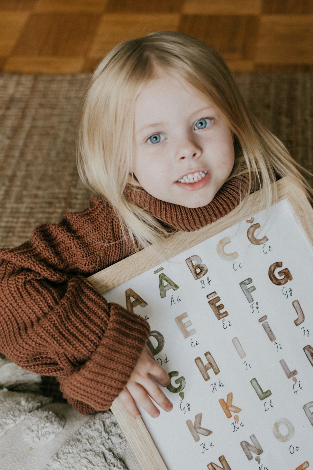 a little girl holding a sign with letters on it