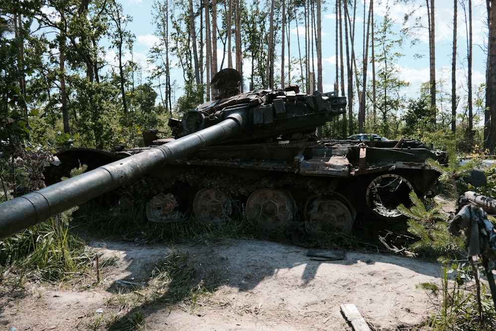 um tanque velho sentado no meio de uma floresta
