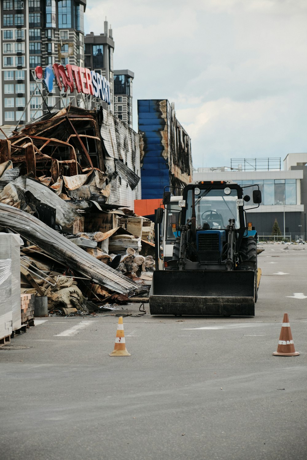 a bulldozer is parked in front of a pile of rubble