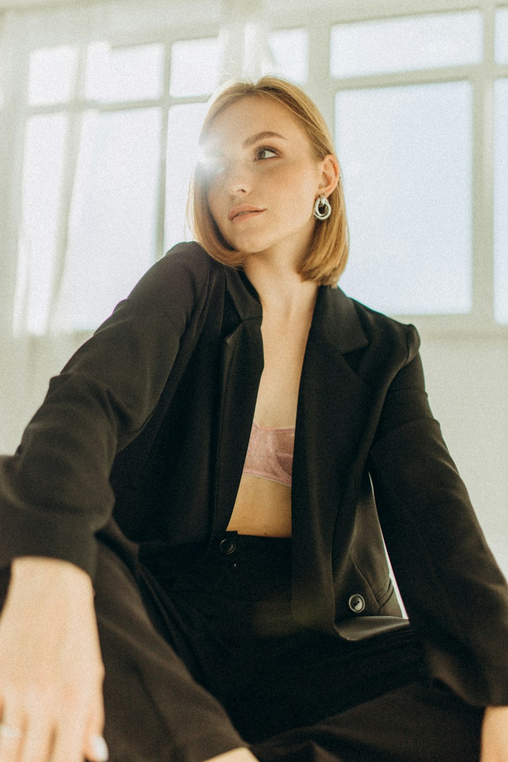 a woman in a black suit sitting on a chair