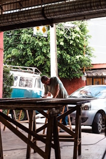 a man working on a table in front of a van