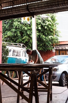 a man working on a table in front of a van